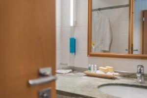 a bathroom with a sink and a mirror at Strand-Hotel Hübner in Warnemünde