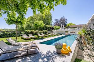 a backyard with a swimming pool with lounge chairs at Le Pavillon M, Piscine et Spa au pied du château, Petit-Déjeuner inclus, Parking privé in Grignan +51 photos