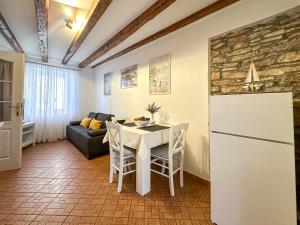 a kitchen and living room with a table and a refrigerator at Apartmani Barica in Novigrad Istria