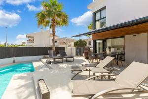 an outdoor patio with chairs and a swimming pool at Escápate a nuestra hermosa casa en Santiago de la Ribera in Santiago de la Ribera