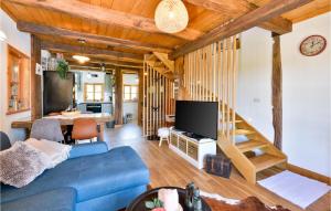 a living room with a blue couch and a tv at Lovely Home In Starcevljani in Starčevljani