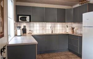 a kitchen with gray cabinets and a microwave at Gaupe - Hytte 5 in Øvre Ramse