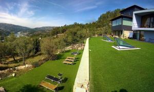 an aerial view of a house with a lawn with lounge chairs at ArsDurium Douro hotel in Cinfães