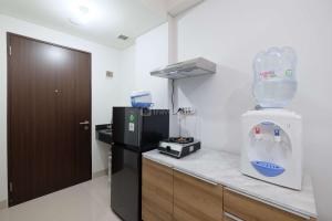 Una cocina con un laboratorio con un dispensador de bebidas en el mostrador. en Simply Look Studio at Transpark Cibubur Apartment By Travelio, en Depok