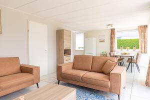 Una sala de estar con dos sillas y una mesa. en Bohemien Resort 3, en Sint Maartenszee