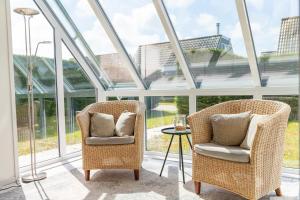 Dos sillas y una mesa en una habitación con ventanas. en Bohemien Resort 3, en Sint Maartenszee
