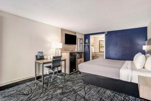 a hotel room with a bed and a desk at Rodeway Inn in Grand Haven