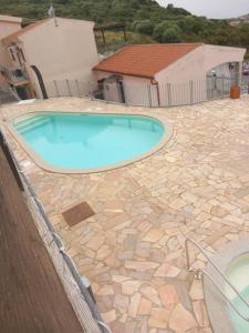 a swimming pool in a yard with a stone patio at Appartamento vista mare FT2 in Cascabraga