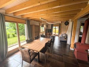 a dining room with a wooden table and chairs at Chalet Sauna jacuzzi 6 personnes in La Bresse