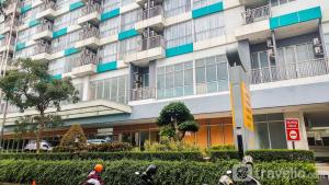 a large apartment building with people on bikes in front of it at Comfortable and Nice Studio Room Apartement at H Residence By Travelio in Jakarta