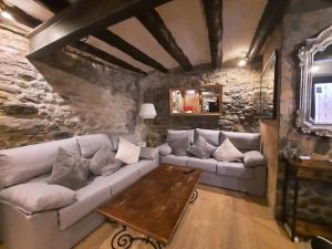 a living room with a couch and a table at CAL ROCCO Porta del Pirineu in La Pobla de Segur