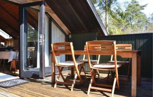 a wooden table and chairs on a deck at Two-Bedroom Holiday Home In Frederiksvark in Frederiksværk