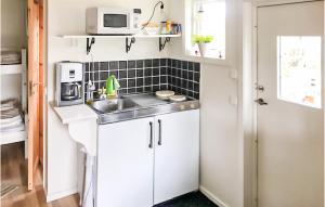 a small kitchen with a sink and a microwave at Gorgeous Apartment In Tjurkö in Sturkö