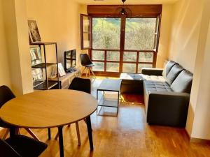 a living room with a couch and a table at La Casina de Noah en Soto de Luiña 304A in Cudillero