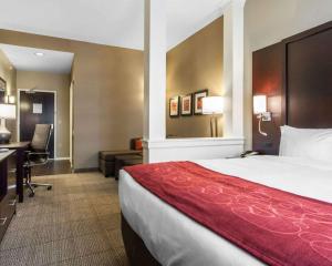a hotel room with a bed and a desk at Comfort Suites-Youngstown North in Youngstown