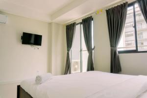 a bedroom with two beds and a window at Luxury Studio at Daan Mogot City Apartment By Travelio in Jakarta