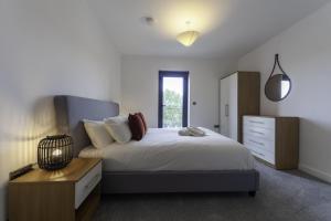 a bedroom with a large bed and a dresser at Lovely 2 Bedroom Apartment in Central Ashford in Ashford