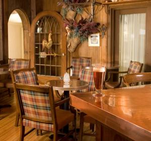 uma sala de jantar com mesas e cadeiras e uma bebida sobre uma mesa em The Manor on Golden Pond em Holderness