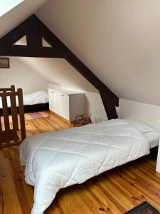 a bedroom with a white bed in a attic at Ty Ker-sa classé 2 étoiles in Ploubazlanec