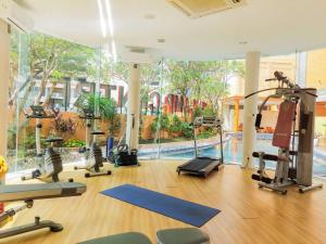 a gym with treadmills and exercise equipment and a pool at Studio Loft No Kitchen Mezzanine at Kubikahomy Apartment By Travelio in Tangerang