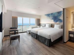 a hotel room with a bed and a view of the ocean at Grand Mercure Okinawa Cape Zanpa Resort in Yomitan