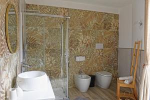 a bathroom with a shower with a sink and a toilet at CasAmuri Exclusive Apartments in Noto