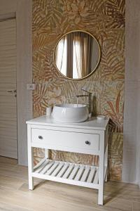 a bathroom with a white sink and a mirror at CasAmuri Exclusive Apartments in Noto