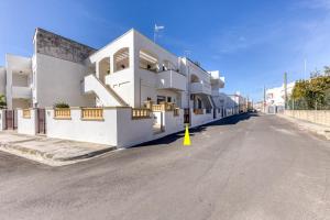 a white building with a yellow cone in the street at Meliso in Leuca