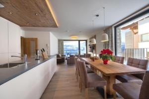 a kitchen and dining room with a wooden table and chairs at Edelweisshaus Top 8 in Königsleiten