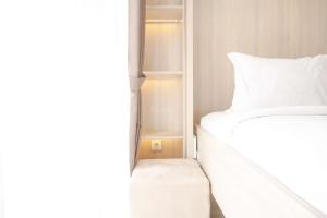 ein Schlafzimmer mit einem weißen Bett und einem weißen Kissen in der Unterkunft Best Choice and Nice Studio at Sky House BSD Apartment By Travelio in Tangerang + 8 Fotos
