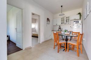 a kitchen and dining room with a table and chairs at Geräumige Ferienwohnung im Erdgeschoss mit Meerblick vom privaten Balkon in Kožino +14 photos