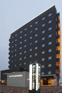 un edificio negro con un cartel delante en AZ Inn Higashi Omi Notogawa Ekimae, en Higashiomi