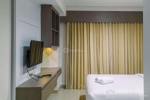 Beran-kidulCozy Studio Room at Patraland Amarta Apartment By Travelio的一间配有床和电视的酒店房间