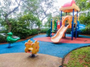 einen Spielplatz mit Rutsche und Spielstruktur in der Unterkunft Modern Look 1BR Apartment at Scientia Residence By Travelio in Tangerang