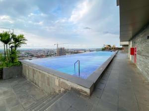 a swimming pool on the roof of a building at Best Deal and Strategic 2BR Marquis de Lafayette Apartment By Travelio in Semarang