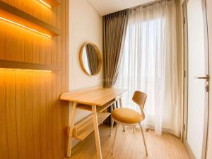 a desk and a chair in a room with a window at Best Deal and Strategic 2BR Marquis de Lafayette Apartment By Travelio in Semarang +9 photos