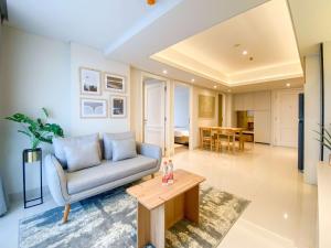 a living room with a couch and a table at Best Deal and Strategic 2BR Marquis de Lafayette Apartment By Travelio in Semarang
