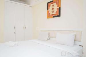 当格浪Fully Furnished with Comfortable Design 1BR Apartment Silkwood Residences By Travelio的白色卧室里有两张白色床，墙上挂着一幅画 更多10张照片