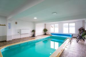 a pool with blue water in a building at Perla Brazilor in Frumosu