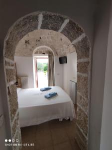 a bedroom with a bed in a stone archway at Trulli del boschetto in Putignano