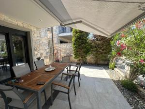 a wooden table and chairs on a patio with an umbrella at Villa Stephanie in Hanioti