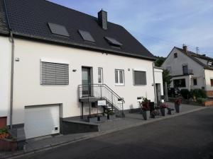a white house with solar panels on the roof at Ferienwohnung Alexandra in Wintrich in Wintrich