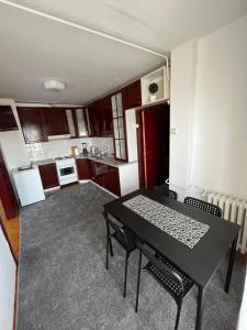 a small kitchen with a black table and chairs at Devetka in Pirot +7 photos