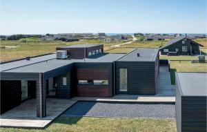 a house with a black roof on top of a field at Three-Bedroom Holiday Home In Lokken in Løkken