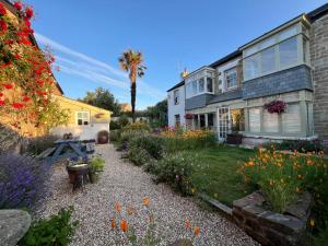 a garden with flowers in front of a house at Penwyth House in Newquay