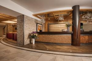 a lobby of a restaurant with a counter with flowers at miaflor Familien- & Aktivresort in Ried im Oberinntal +54 photos