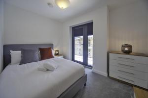 a bedroom with a white bed and a window at Stunning 2 Bedroom Apartment in Central Ashford in Ashford