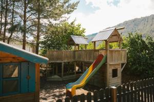 a playground with a slide and a play house at miaflor Familien- & Aktivresort in Ried im Oberinntal