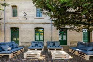 un groupe de canapés et de tables bleus devant un bâtiment dans l'établissement Hotel Rural Estación de la Dehesa, à Almazán