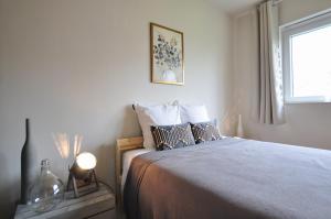 a bedroom with a large bed with a window at Le sourire - Maison avec Jardin, Bureau & BBQ in Rochefort